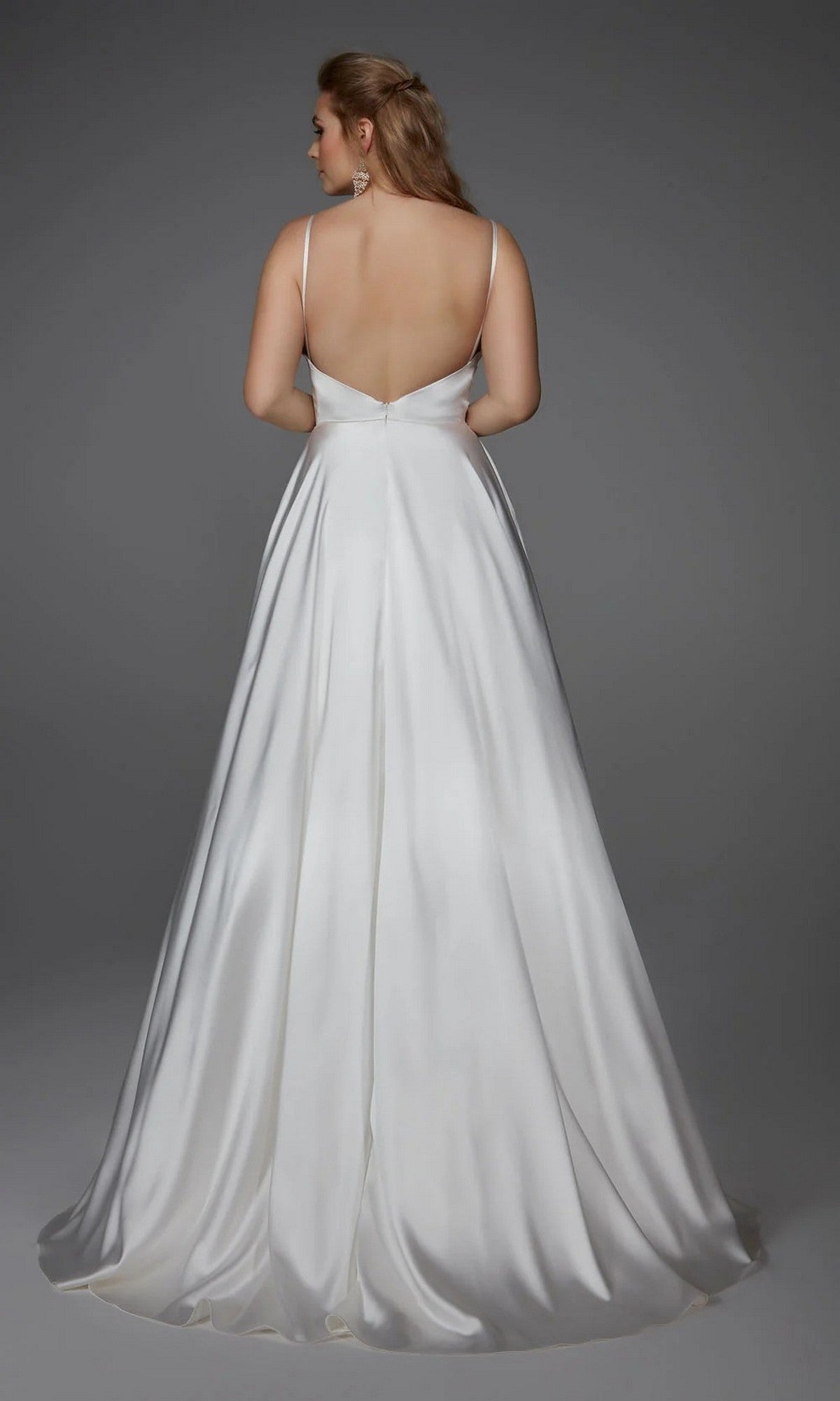 A woman wearing the Long White Dress: Alyce 7009—a sleeveless, floor-length satin bridal gown with a low back—stands against a plain gray background, showcasing the elegance of this minimalist wedding dress.